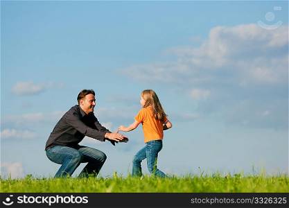 Father and his kid - daughter - playing together at a meadow, at a late summer afternoon, family concept