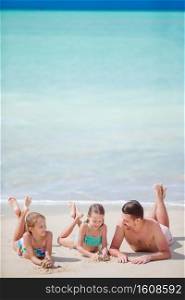 Father and kids enjoying beach summer vacation. Father and little kids enjoying beach summer tropical vacation. Family playing on the beach