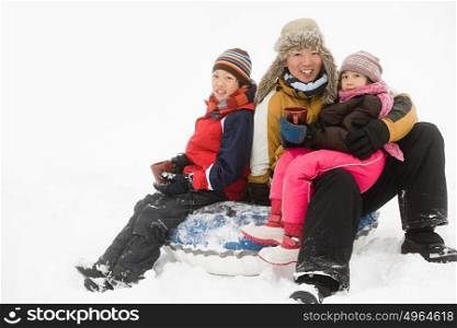 Father and kids having warm drink in snow