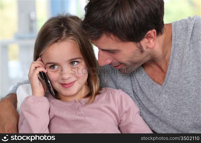 Father and little girl using mobile phone