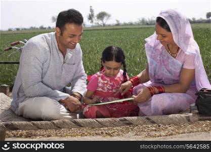 Father and mother assisting daughter with her homework