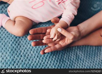 father and mother hold in their hands a little baby&rsquo;s.. Mom and Dad hold baby&rsquo;s hand. Children&rsquo;s handle