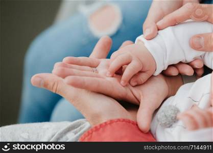 father and mother hold in their hands a little baby&rsquo;s.. Mom and Dad hold baby&rsquo;s hand. Children&rsquo;s handle