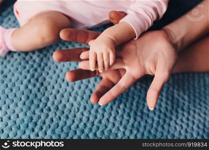 father and mother hold in their hands a little baby's.. Mom and Dad hold baby's hand. Children's handle