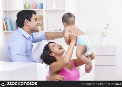 Father and mother playing with baby