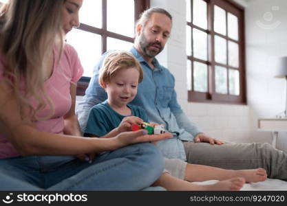 Father and mother with little boy have fun playing with your new toys in the bedroom together. Toys that enhance children’s thinking skills.