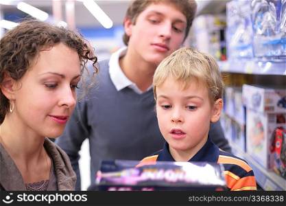 Father and mother with son with toy in shop