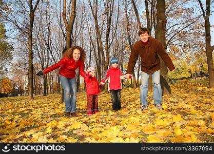 father and mother with the children in the park in autumn