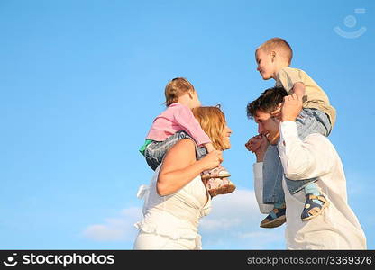 father and mother with the children on the shoulders 2