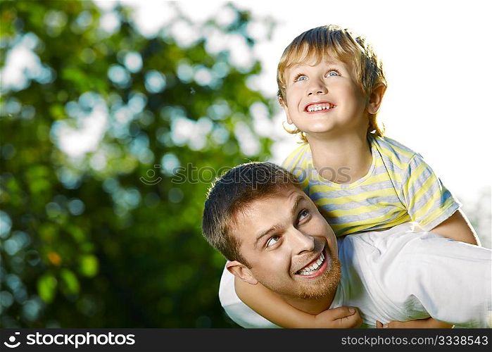 Father and small son frolic in a summer garden