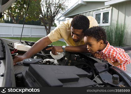 Father and son (5-6) repairing car&acute;s engine