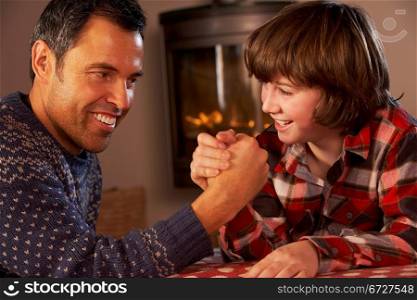 Father And Son Arm Wrestling By Cosy Log Fire