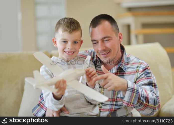 father and son assembling airplane toy at modern home living room indoor