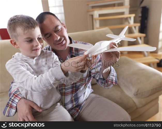 father and son assembling airplane toy at modern home living room indoor