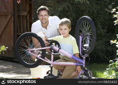 Father And Son Cleaning Bike Together