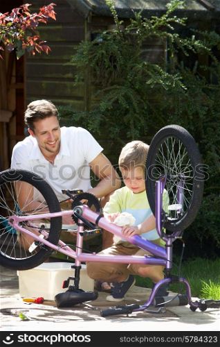 Father And Son Cleaning Bike Together
