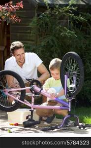 Father And Son Cleaning Bike Together