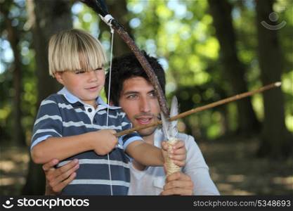 Father and son doing archery