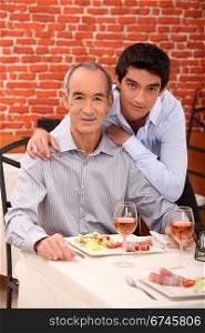 Father and son eating together in restaurant