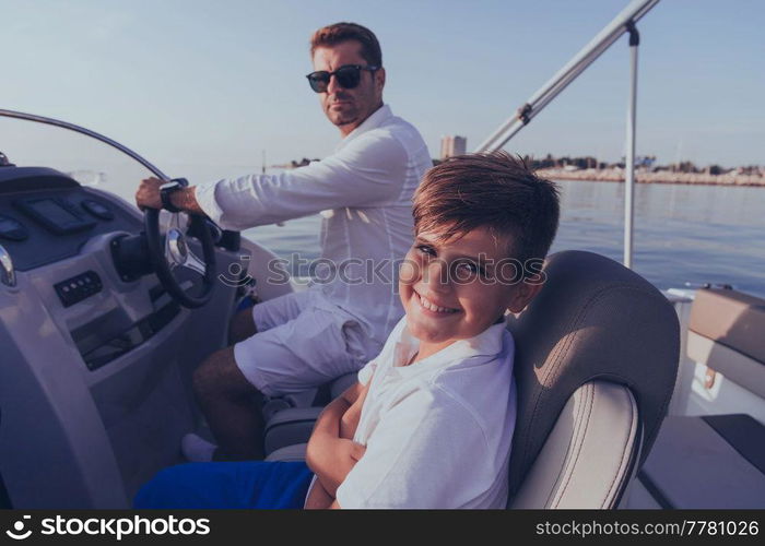 Father and son enjoy their vacation together while riding a luxury boat at sea. Selective focus. High-quality photo. Father and son enjoy their vacation together while riding a luxury boat at sea. Selective focus