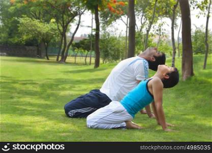 Father and son exercising in park
