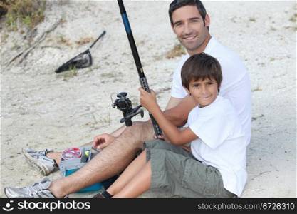 father and son fishing at riverbank