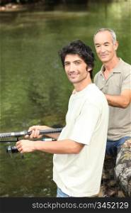 father and son fishing by a river