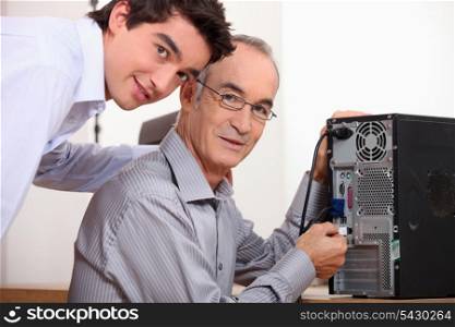 Father and son fixing a computer