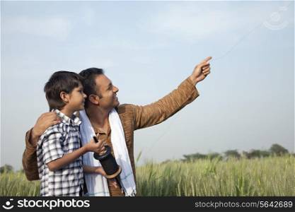 Father and son flying a kite in field