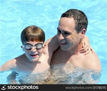 Father and son having fun in a swimming pool