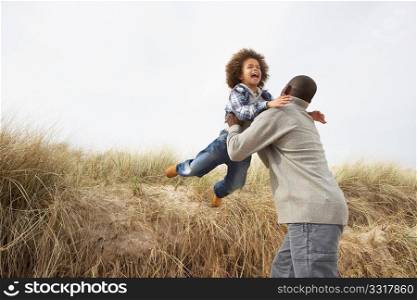 Father And Son Having Fun In Sand Dunes