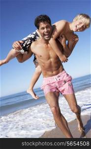 Father And Son Having Fun On Beach