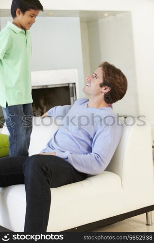 Father And Son Having Fun On Sofa Together