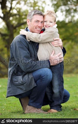Father And Son Hugging On Outdoor Autumn Walk