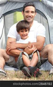 Father and son in front of their tent
