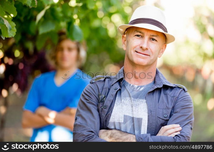 Father and son in vineyard. Father and son standing in vineyard