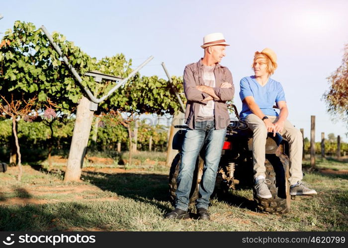 Father and son in vineyard. Father and son standing next to car in vineyard