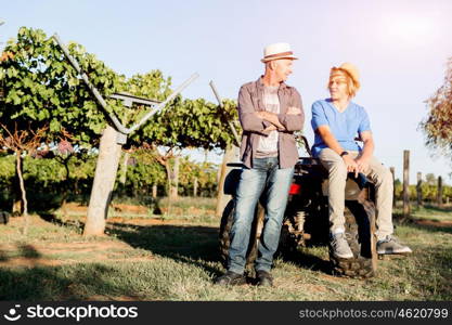 Father and son in vineyard. Father and son standing next to car in vineyard