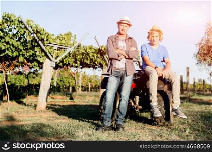 Father and son in vineyard. Father and son standing next to car in vineyard