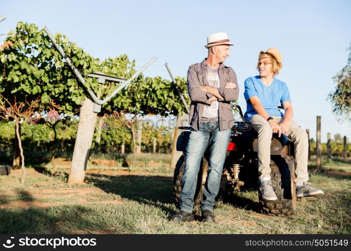 Father and son in vineyard. Father and son standing next to car in vineyard