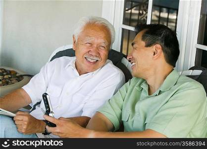 Father and Son Laughing and Using Cell Phone