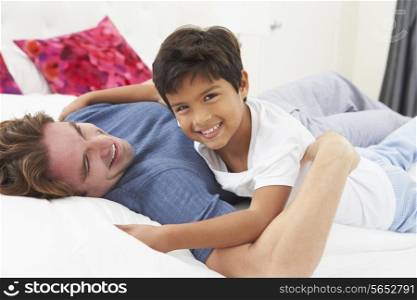 Father And Son Lying In Bed Together