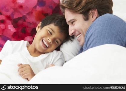 Father And Son Lying In Bed Together