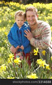 Father And Son On Easter Egg Hunt In Daffodil Field