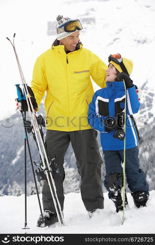 Father And Son On Ski Holiday In Mountains