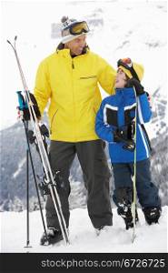 Father And Son On Ski Holiday In Mountains
