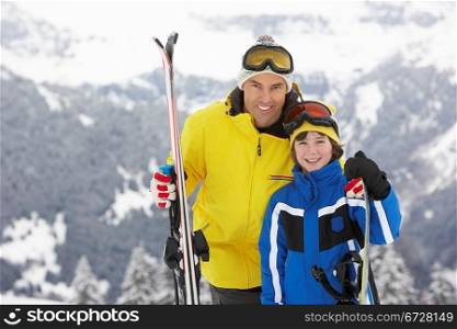 Father And Son On Ski Holiday In Mountains
