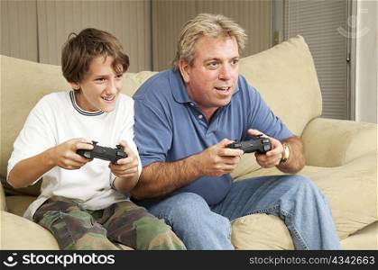 Father and son or uncle and nephew, playing video games at home.