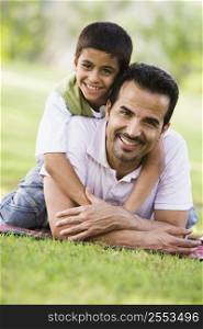Father and son outdoors in park embracing and smiling (selective focus)