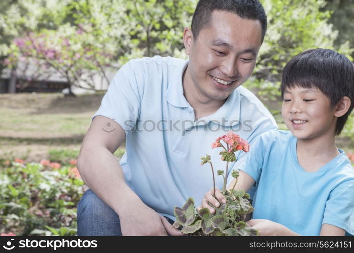 Father and son planting flowers.